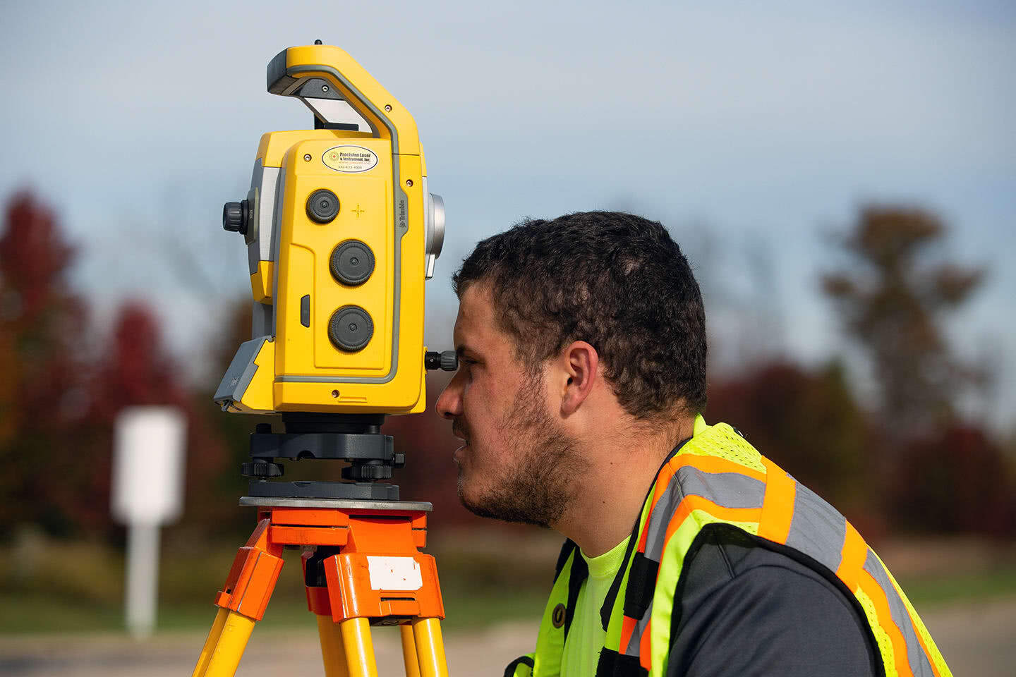 Close-up photo of surveyor using surveying equipment.